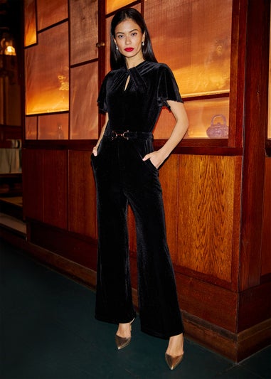 Yumi Black Velvet Jumpsuit With Twist Neckline & Buckle Belt