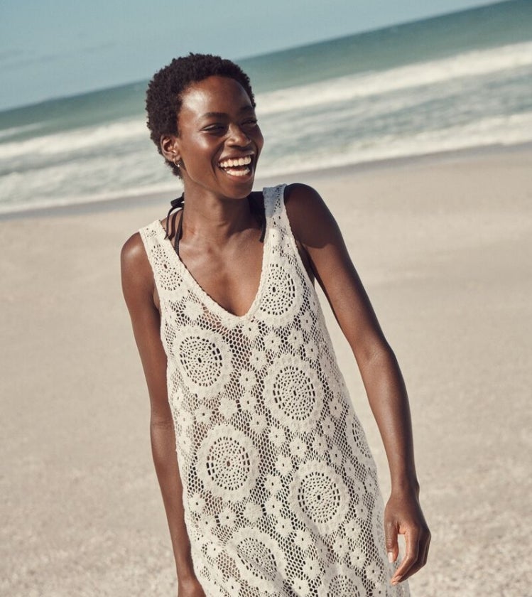 Woman wearing crochet beach cover up dress on the beach
