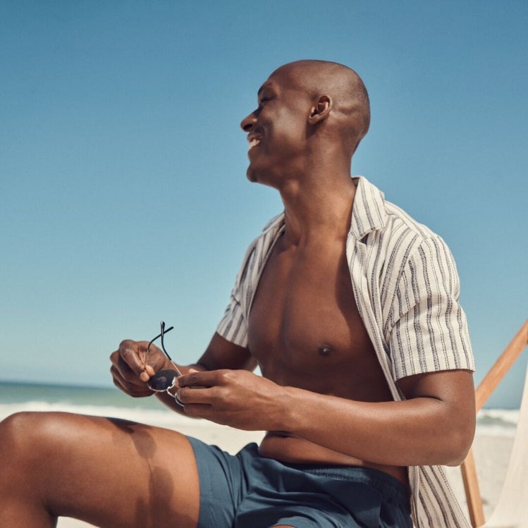 Man wearing shirt and shorts on the beach