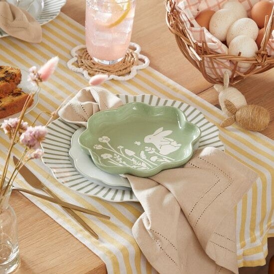 Easter place setting with bunny themed plate and a floral table cloth.
