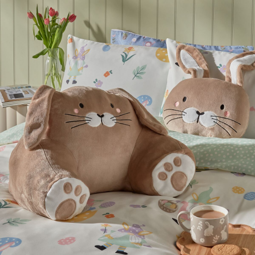 Bunny themed cuddle cushion on a bed.