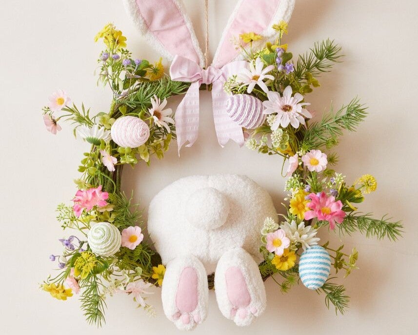 Easter wreath with artificial flowers and Easter eggs on it.